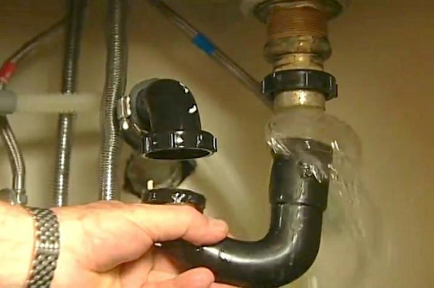 Man unclogging P Trap under sink
