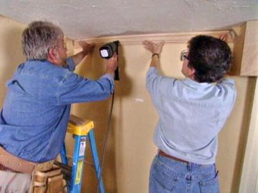 Using nail gun to nail crown molding on wall