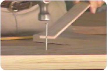 using a strip of wood to hold a nail