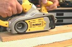 sanding a piece of wood placed on a shelf liner