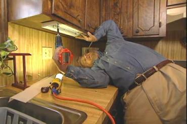 fastening the undercabinet light with screws