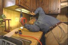fastening the undercabinet light with screws