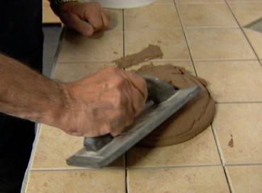 applying grout to the tile